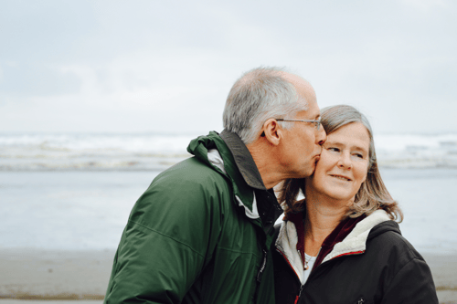 Older couple kissing on a beach
