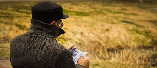 Man reading book outdoors