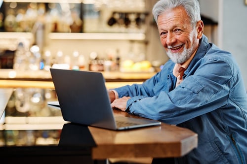 Senior aged man on his laptop at a coffeeshop