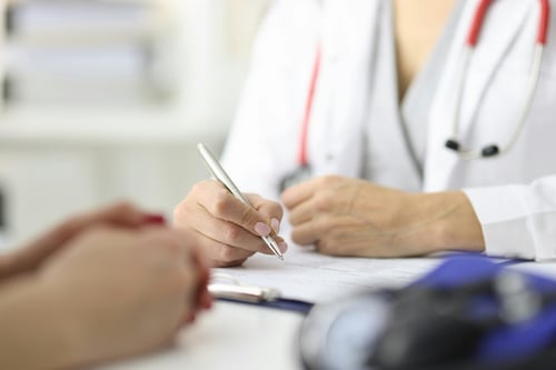 Doctor writing on chart