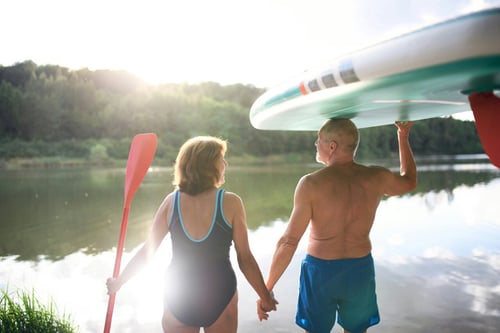 older couple about to paddleboard