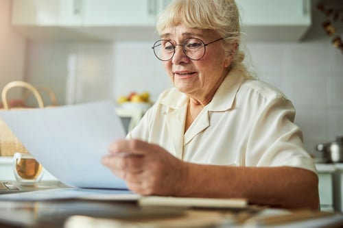 Older woman looking at some information on paper