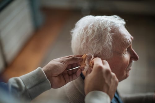 Older man getting fitted for hearing aid