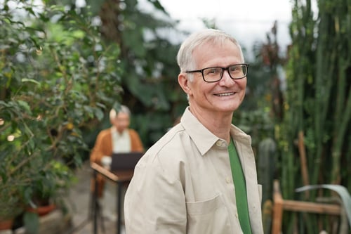 A man wearing prescription glasses smiling at camera