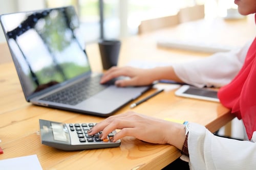 someone using calculator and laptop