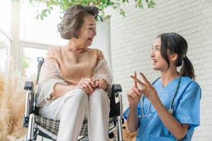 young-caregiver-helping-senior-woman-in-LTC