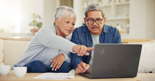 Senior couple researching Minnesota Medigap rule changes on a laptop in their living room.