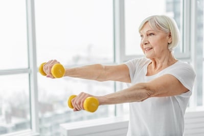 senior woman holding yellow hand weights