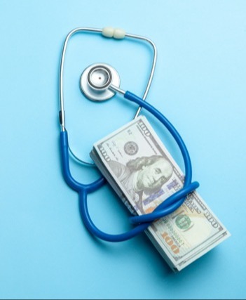 doctor's stethoscope wrapped around hundred dollar bills on blue background illustrating expensive hospital health care costs