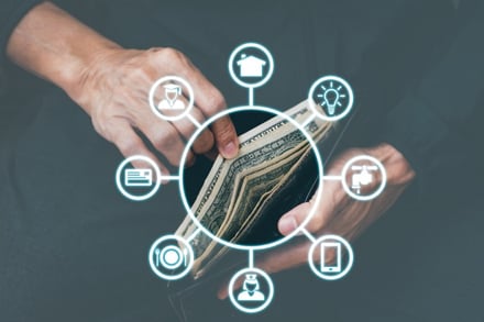 open wallet with cash in hands with icon graphics surrounding depicting every day expenses